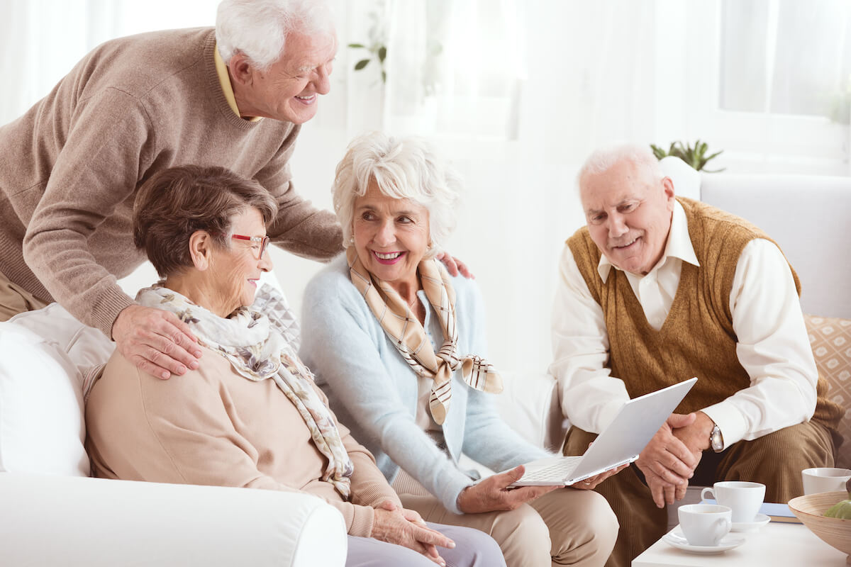 Groups of seniors on sofe looking at laptop-HarborChase Senior Living