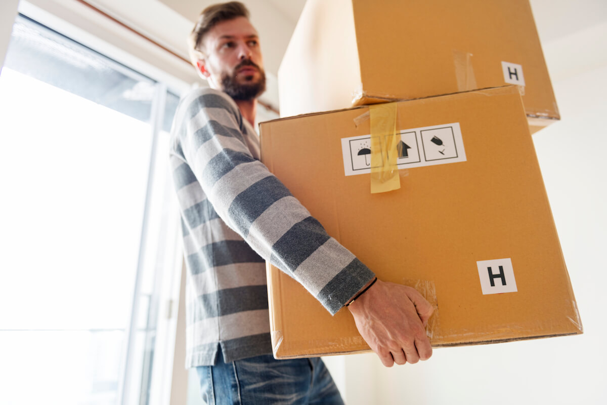 Man carrying two moving box-Benefits of clutter free living