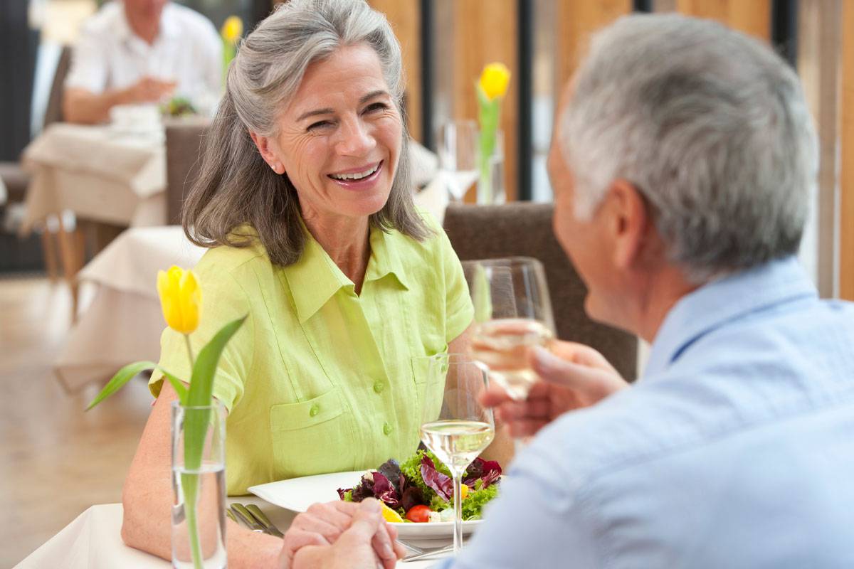 Older couple dining together, drinking wine