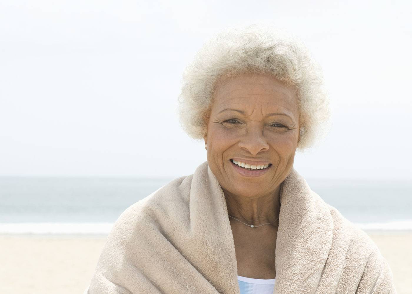 Close up of older African woman standing on beach