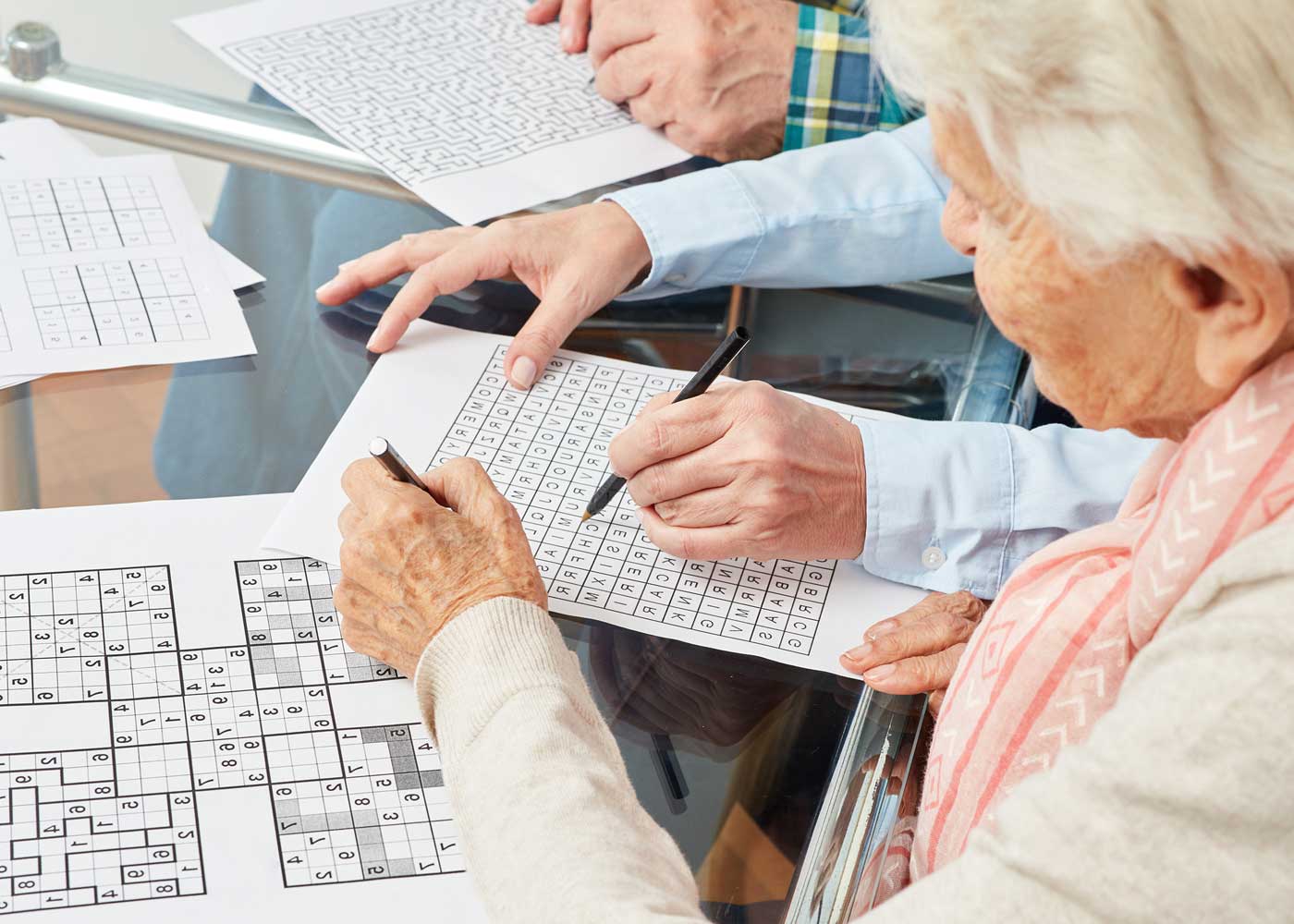 Older woman completing puzzle, strengthening cognitive function