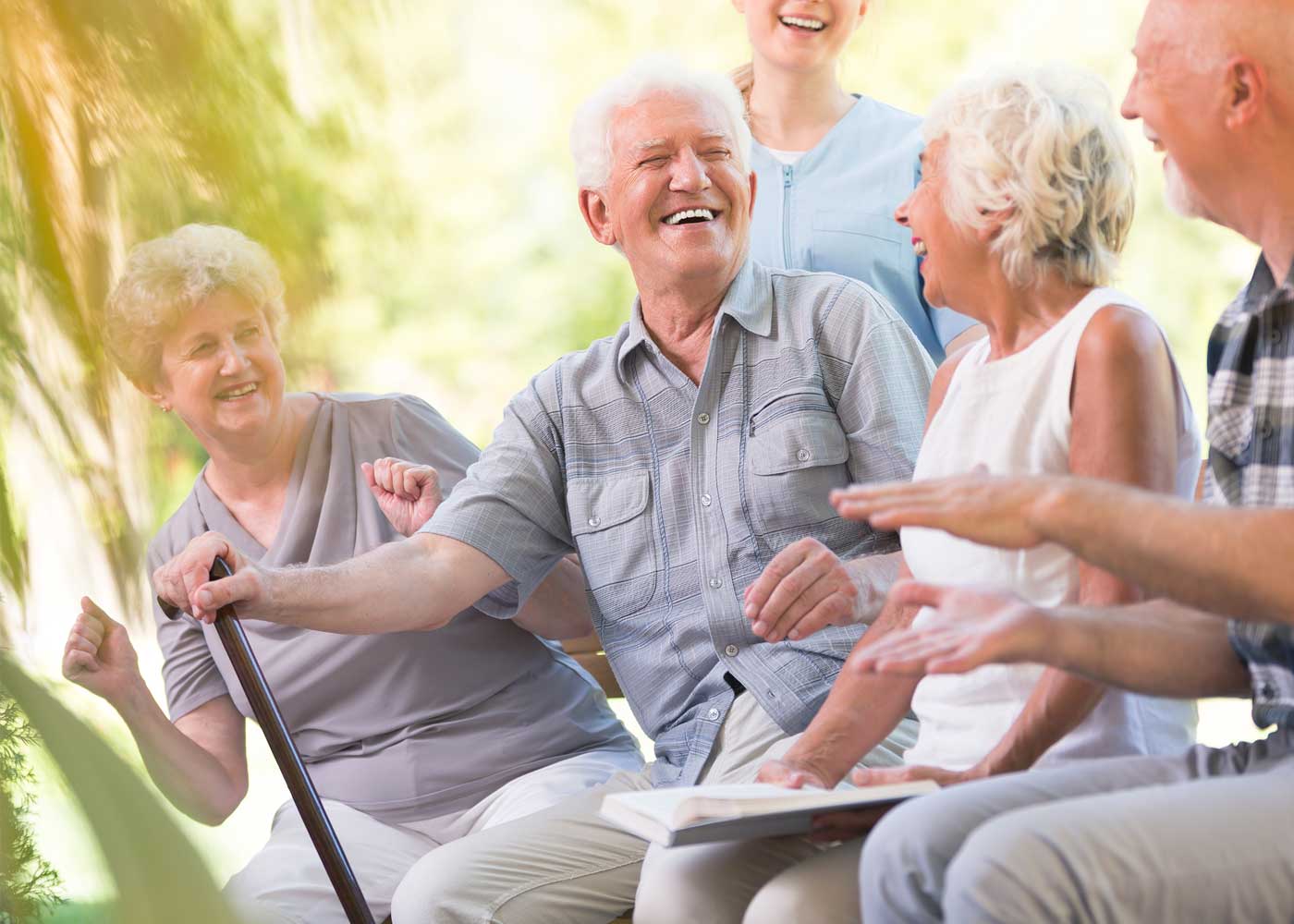 Group of older adults sitting outside, smiling together