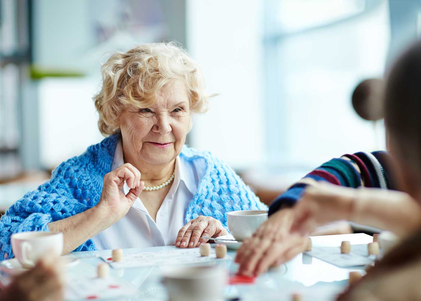 Older Woman Sitting at Table Enjoying Coffee-Luxury Senior Living Community in Wellington, Florida
