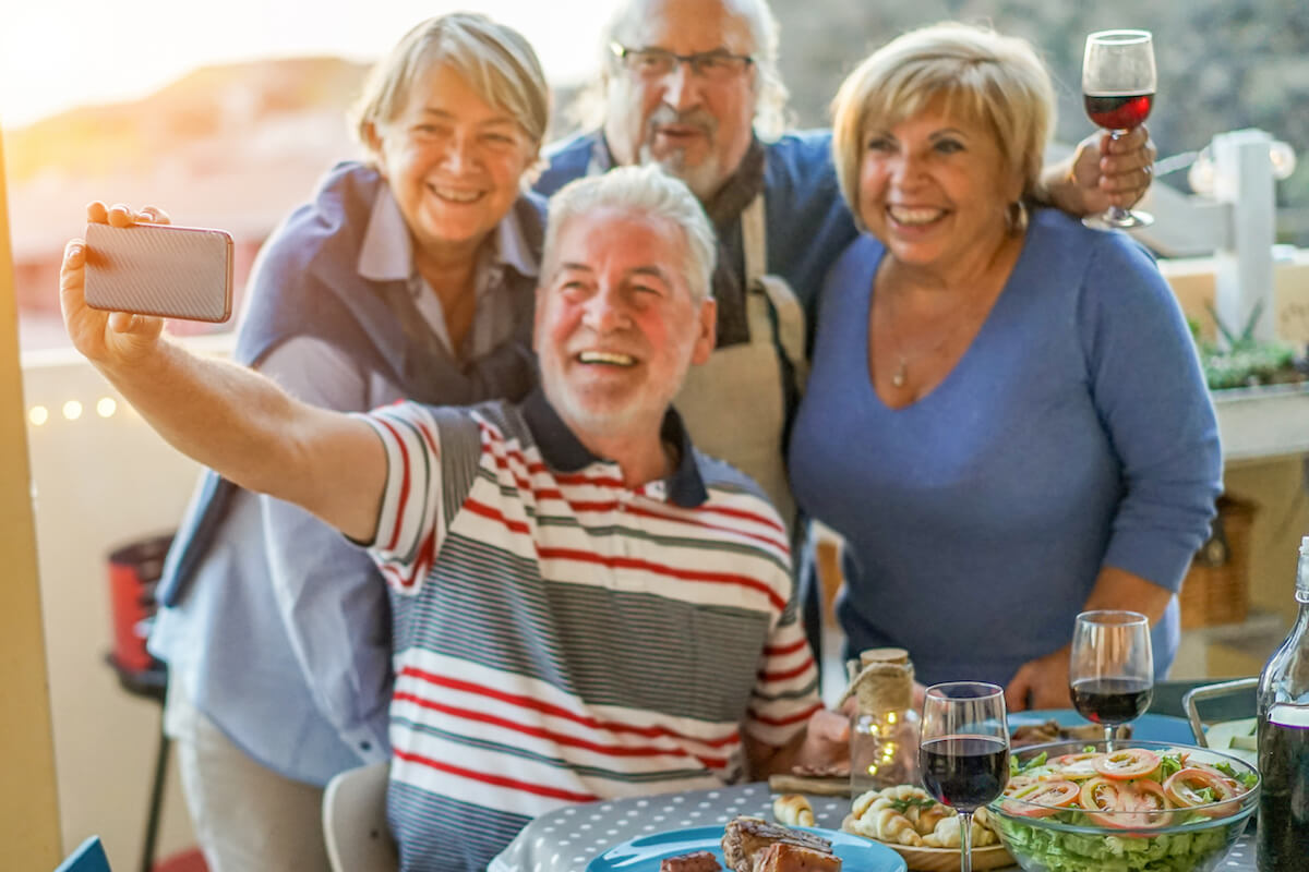 Group of Seniors Taking Photo at Outdoor Dinner-Celebrating Senior Living