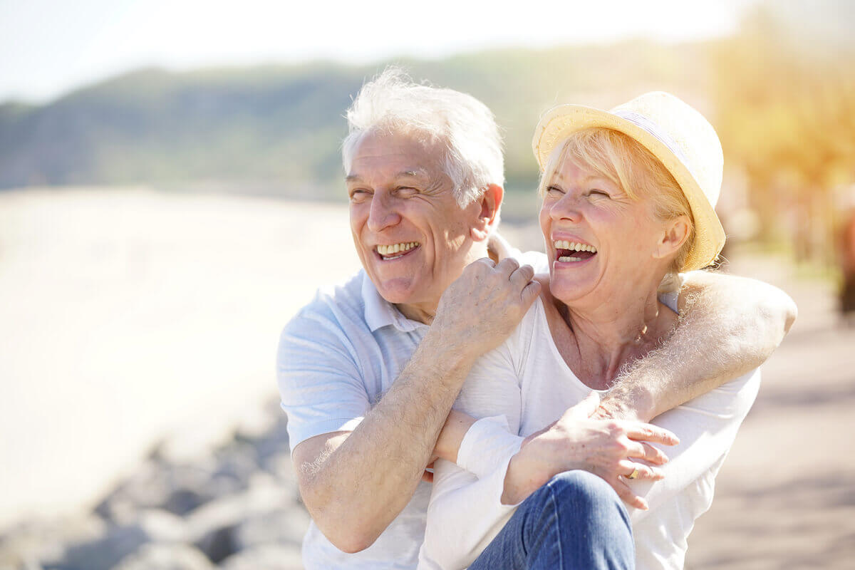 Older couple smiling at the beach-Getting better with age