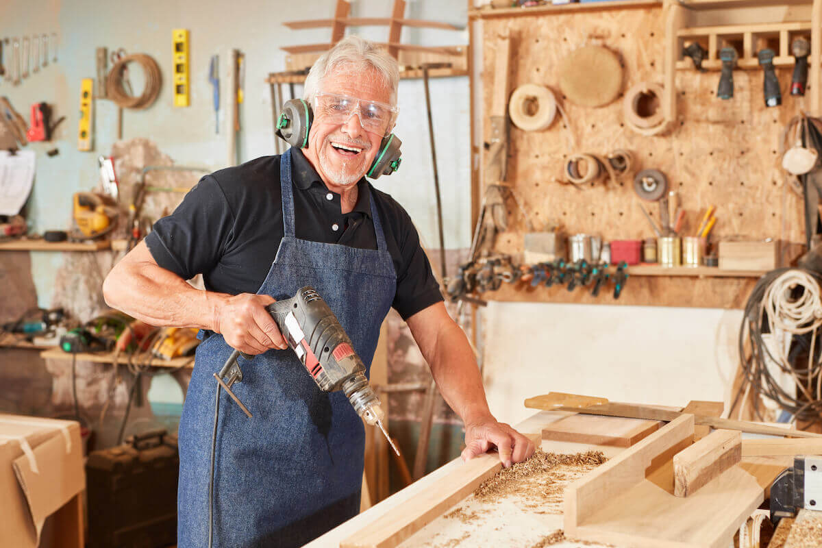 Older man woodworking, holding drill-Fun and Healthy Hobbies