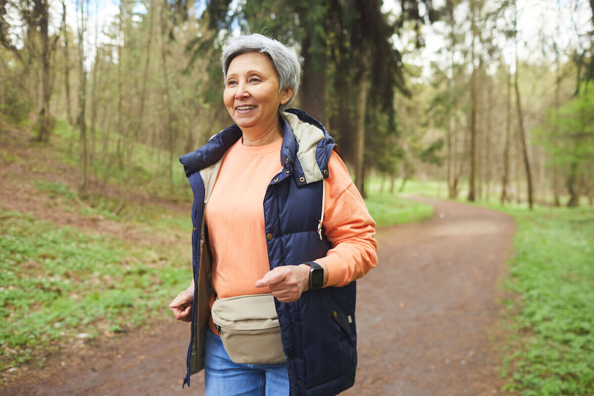 Older woman hiking on outdoor walking trail-Natural ways to fight fatigue