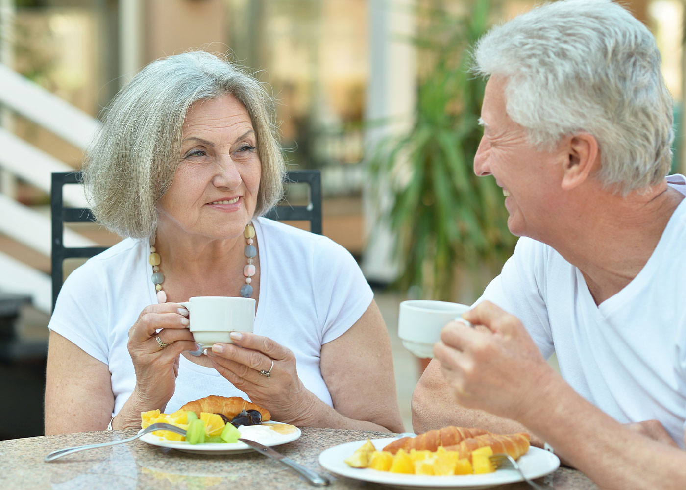 Older couple eating breakfast-smiling at each other-Dining at HarborChase of Long Grove