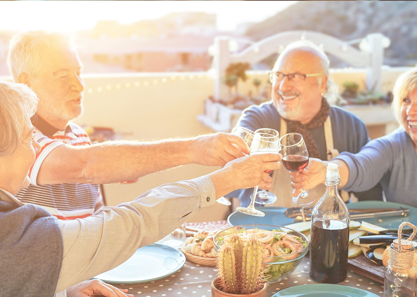 Group of older adults clinking glasses, outdoor dining-Dining at HarborChase of Stuart, Florida