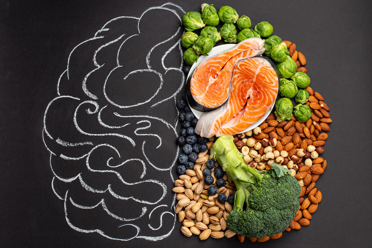 Chalk hand drawn brain with assorted food, food for brain health and good memory fresh salmon fish, green vegetables, nuts, berries