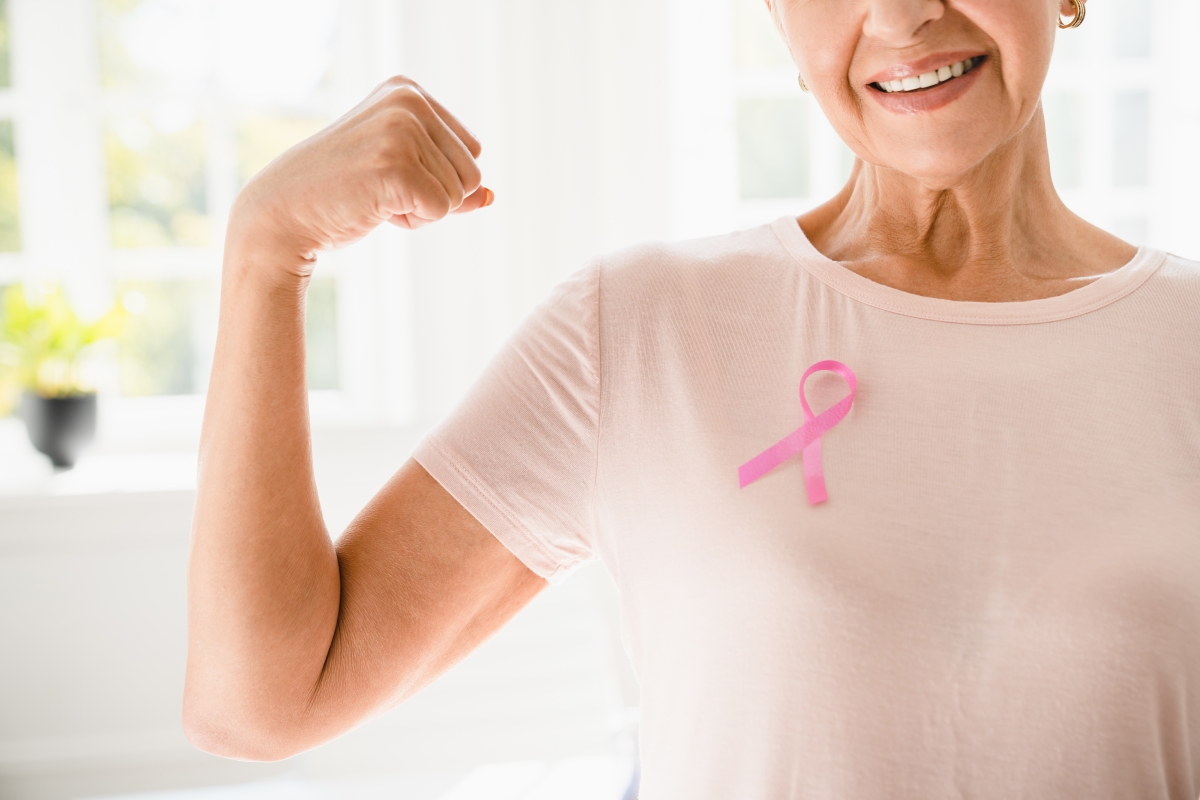 Mature senior elderly strong woman in pink t-shirt with pink ribbon supporting fighting for breast cancer movement.